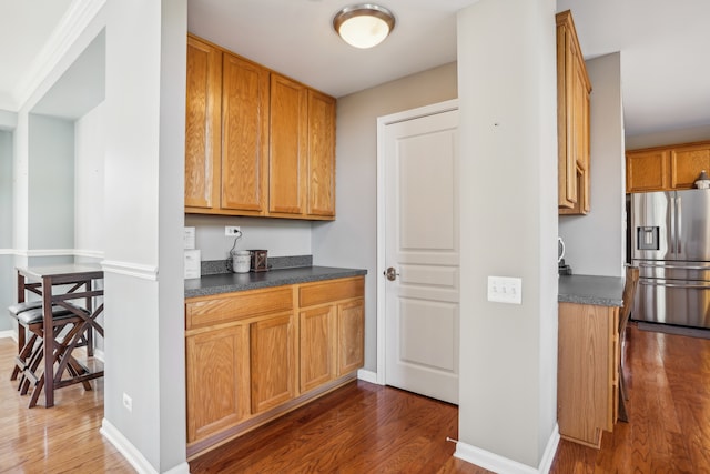 kitchen with stainless steel fridge and dark wood-type flooring