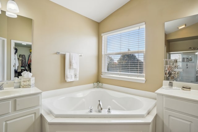 bathroom with vanity, lofted ceiling, and plus walk in shower