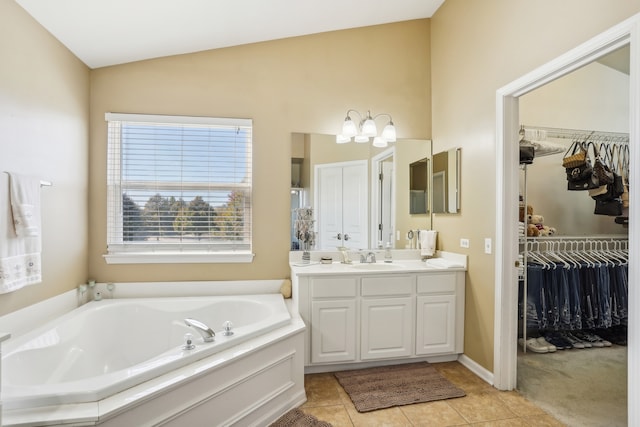 bathroom with vanity, vaulted ceiling, tile patterned flooring, and a bathing tub