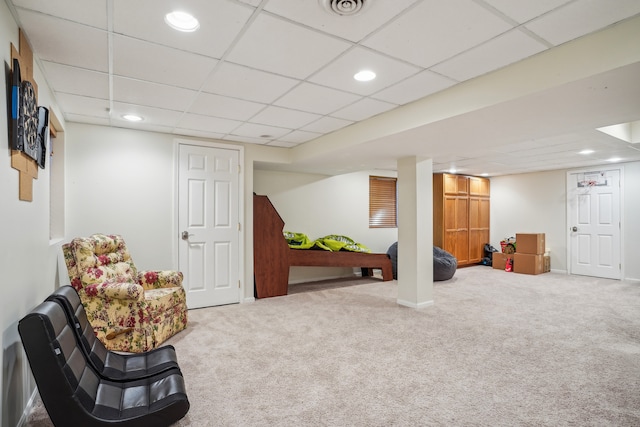 interior space with a paneled ceiling and carpet flooring