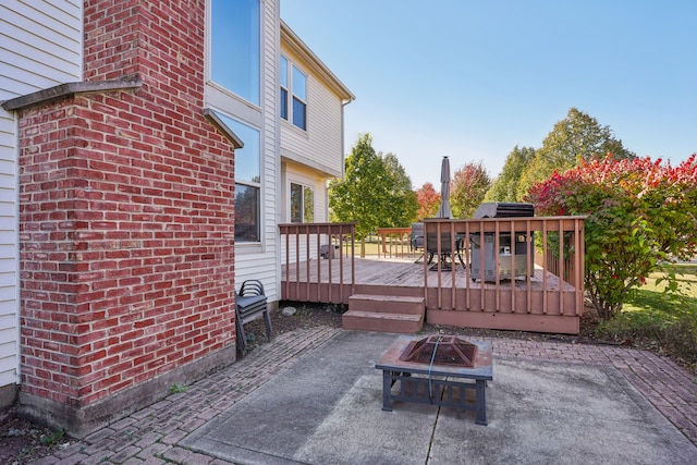 view of patio with an outdoor fire pit and a deck