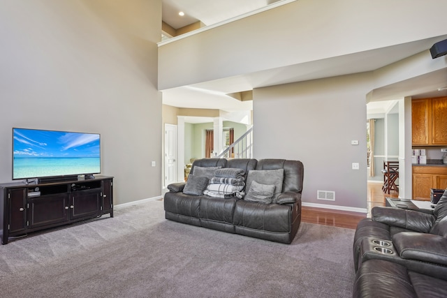 living room featuring carpet and a towering ceiling