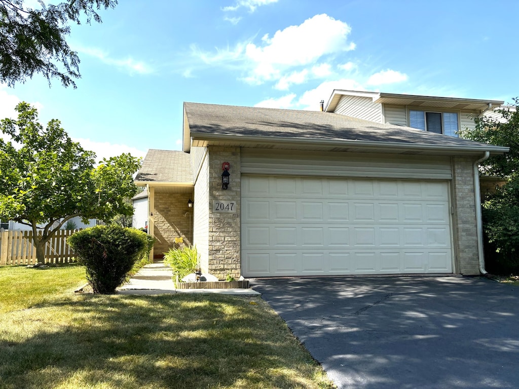 view of front of home featuring a front yard and a garage