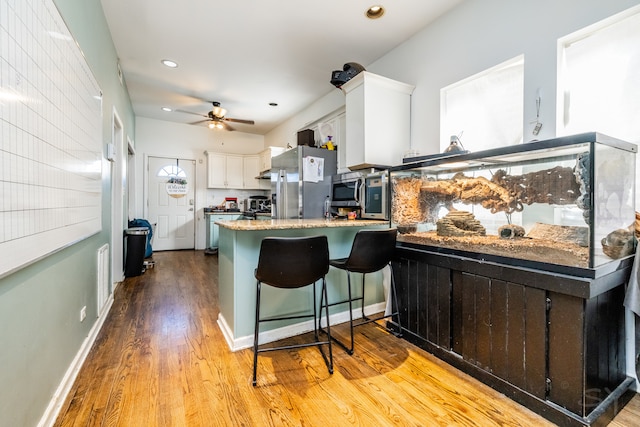 kitchen with light hardwood / wood-style flooring, kitchen peninsula, stainless steel fridge with ice dispenser, white cabinets, and ceiling fan