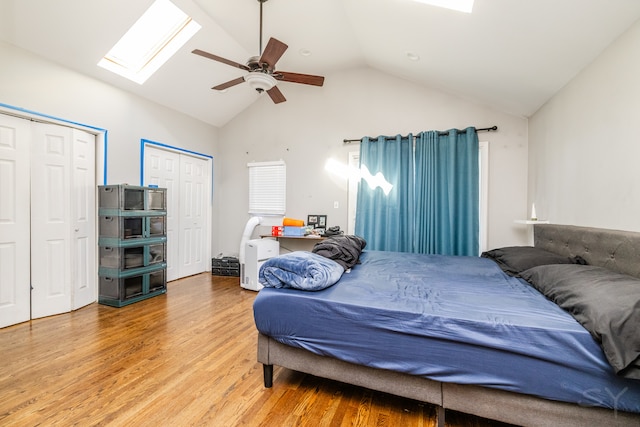 bedroom featuring vaulted ceiling, two closets, wood-type flooring, and ceiling fan