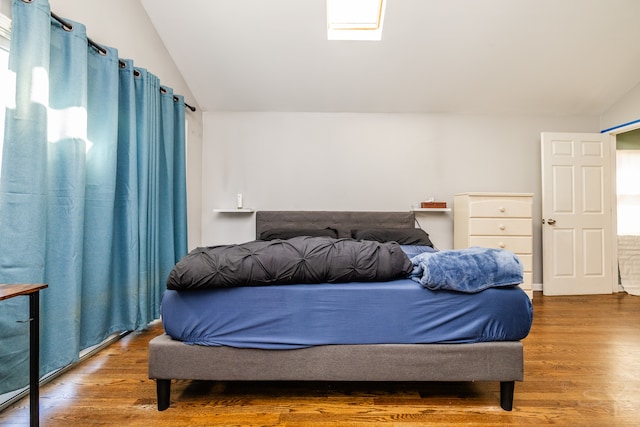 bedroom with hardwood / wood-style flooring and vaulted ceiling