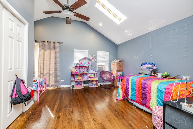 bedroom with ceiling fan, lofted ceiling with skylight, and hardwood / wood-style floors