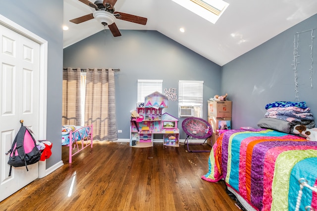 bedroom with lofted ceiling with skylight, cooling unit, dark hardwood / wood-style flooring, and ceiling fan