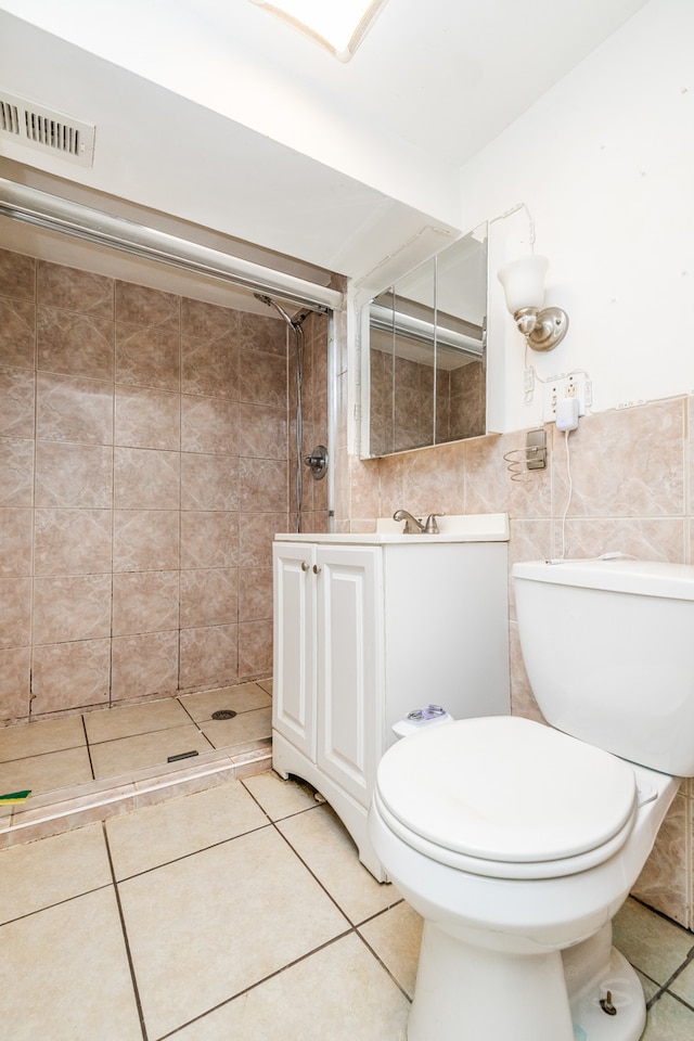 bathroom featuring toilet, vanity, tile walls, and tile patterned flooring