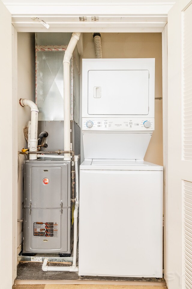 clothes washing area featuring stacked washer and clothes dryer