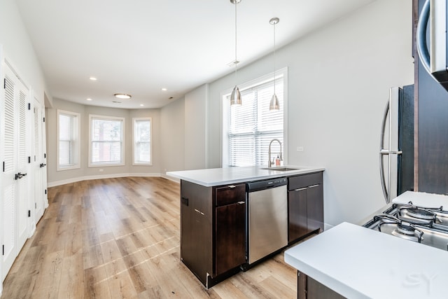 kitchen featuring appliances with stainless steel finishes, decorative light fixtures, plenty of natural light, and a kitchen island