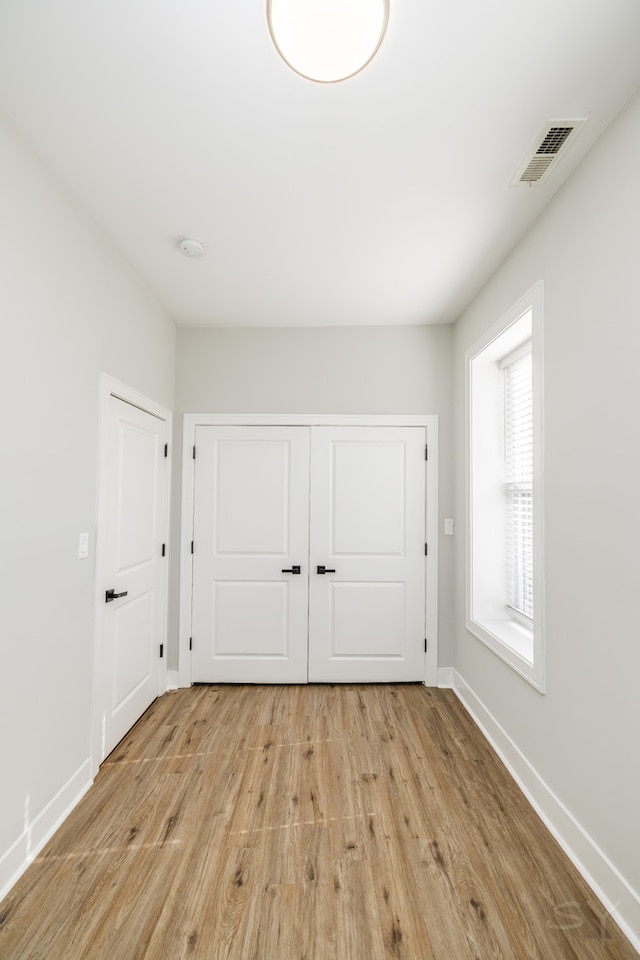 unfurnished bedroom featuring a closet and light wood-type flooring