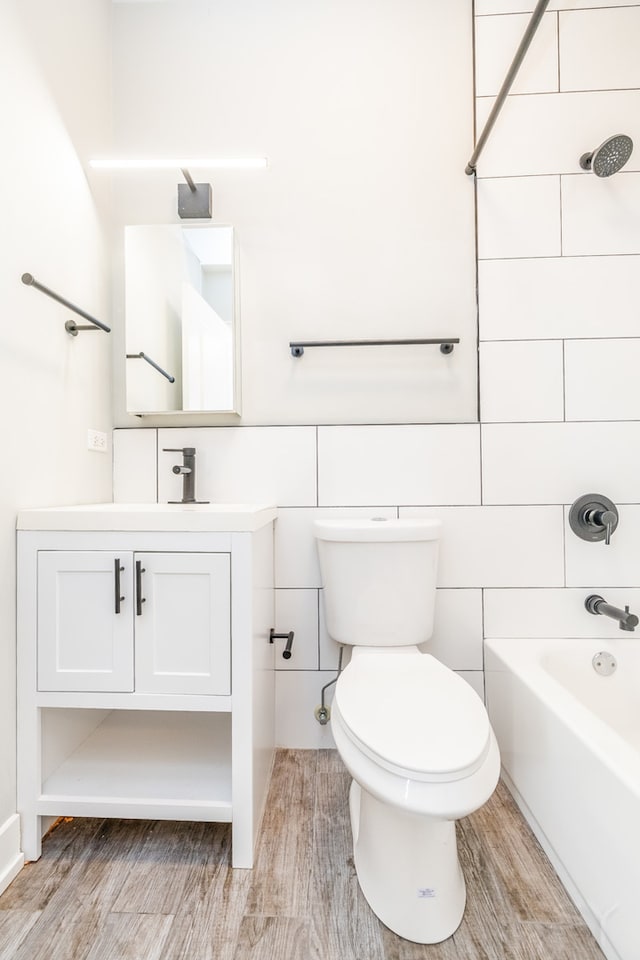 full bathroom featuring vanity, toilet, wood-type flooring, and tiled shower / bath