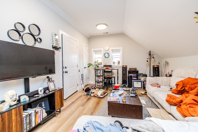 living room featuring light wood-type flooring and vaulted ceiling