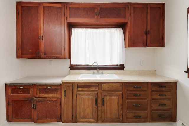 kitchen featuring a baseboard heating unit and sink