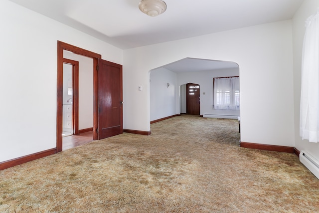 carpeted empty room with baseboard heating