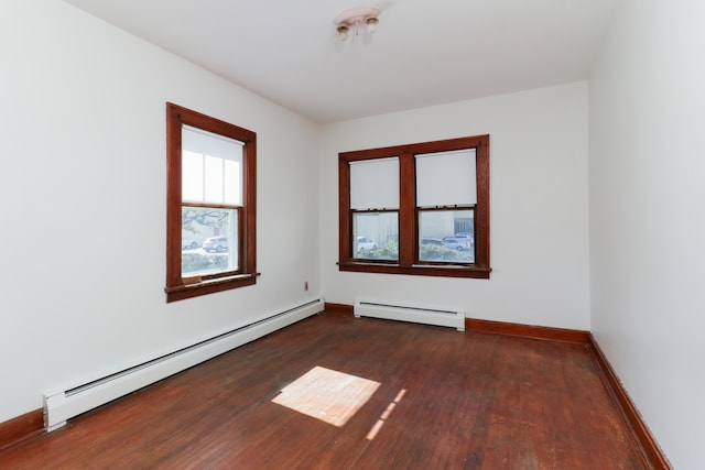 spare room with dark hardwood / wood-style floors and baseboard heating