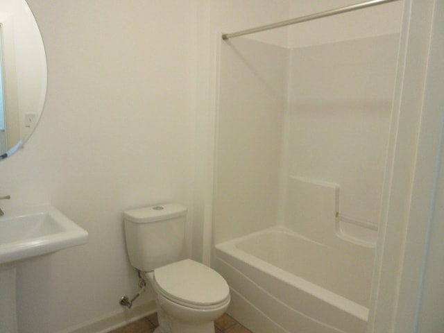 bathroom with tile patterned flooring, shower / bathing tub combination, and toilet