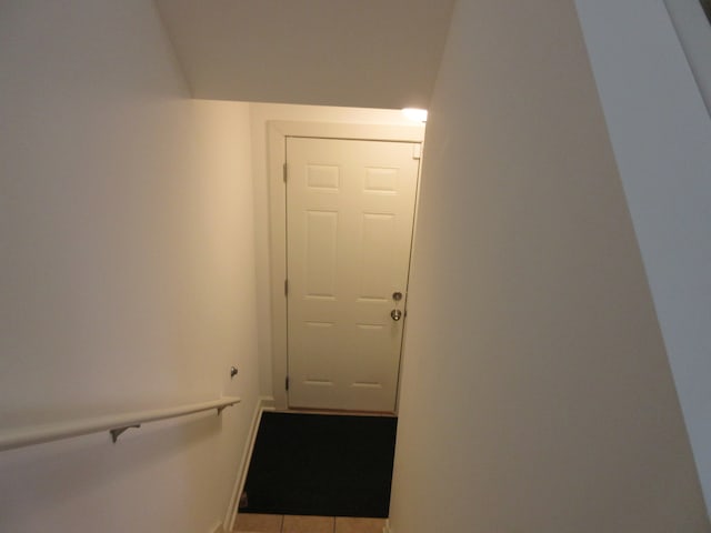 hall with tile patterned floors