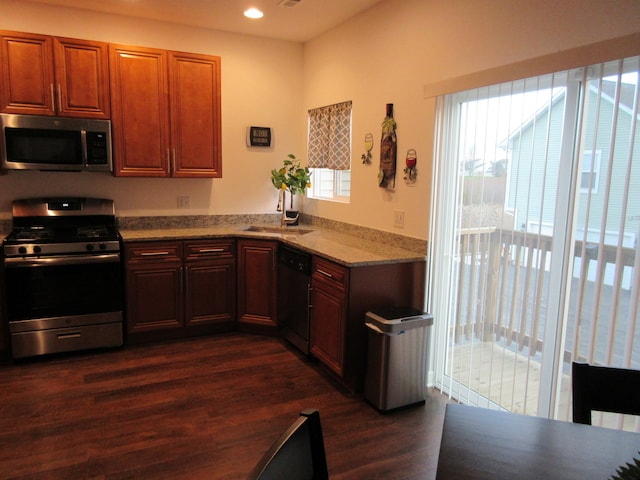 kitchen featuring light stone counters, sink, stainless steel appliances, and dark hardwood / wood-style floors