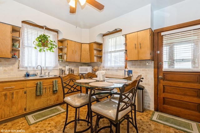 kitchen featuring backsplash, sink, and ceiling fan