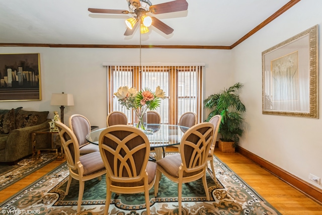 dining room featuring crown molding, wood-type flooring, and ceiling fan