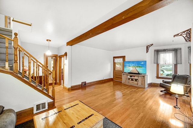 living room with beamed ceiling and light wood-type flooring