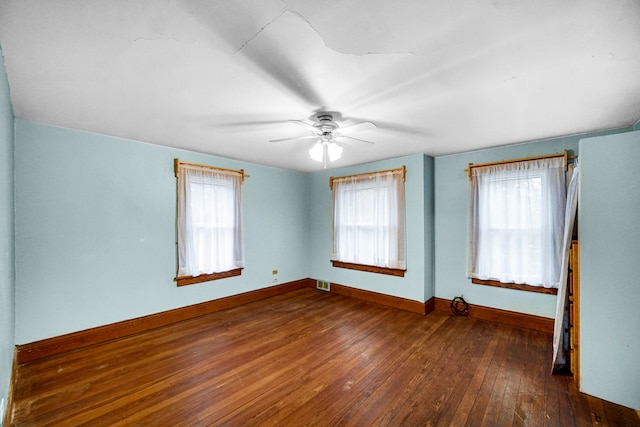 spare room featuring a wealth of natural light, dark wood-type flooring, and ceiling fan