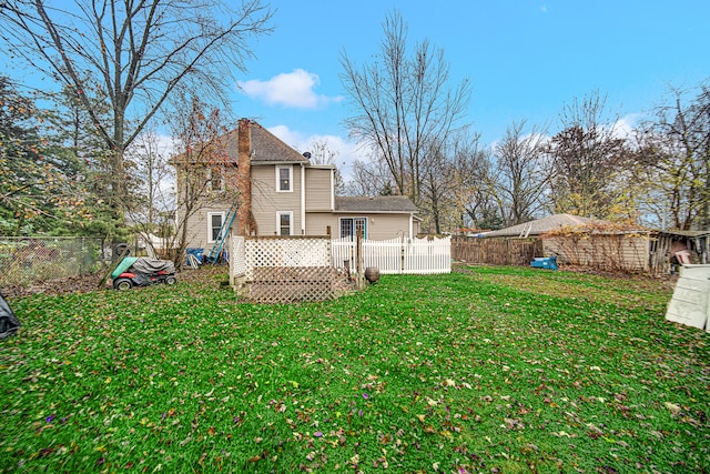 back of property featuring a wooden deck and a yard