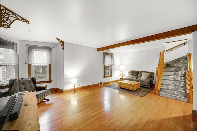 living room featuring wood-type flooring and beam ceiling