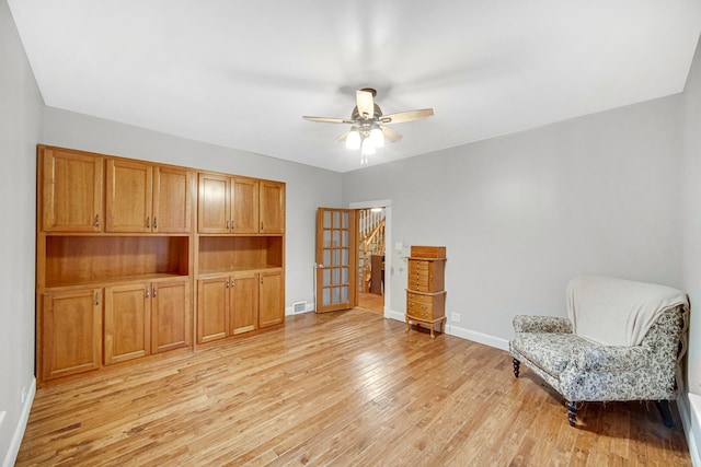 sitting room with ceiling fan and light hardwood / wood-style flooring