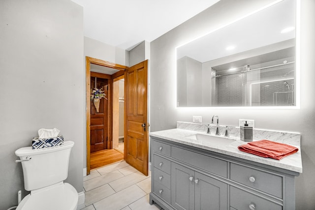 bathroom featuring tile patterned floors, vanity, an enclosed shower, and toilet