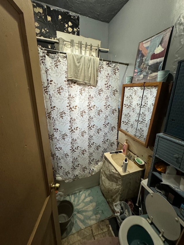 bathroom with a textured ceiling and toilet