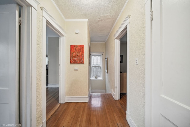 corridor with hardwood / wood-style floors and a textured ceiling