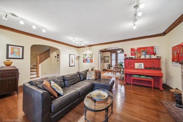 living room featuring dark hardwood / wood-style flooring, track lighting, and ornamental molding