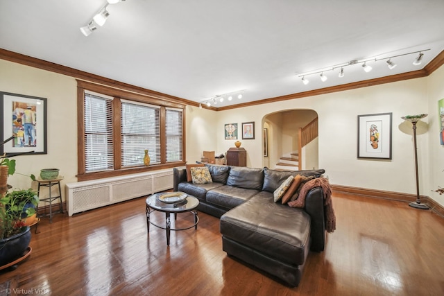 living room featuring hardwood / wood-style flooring, ornamental molding, radiator heating unit, and rail lighting