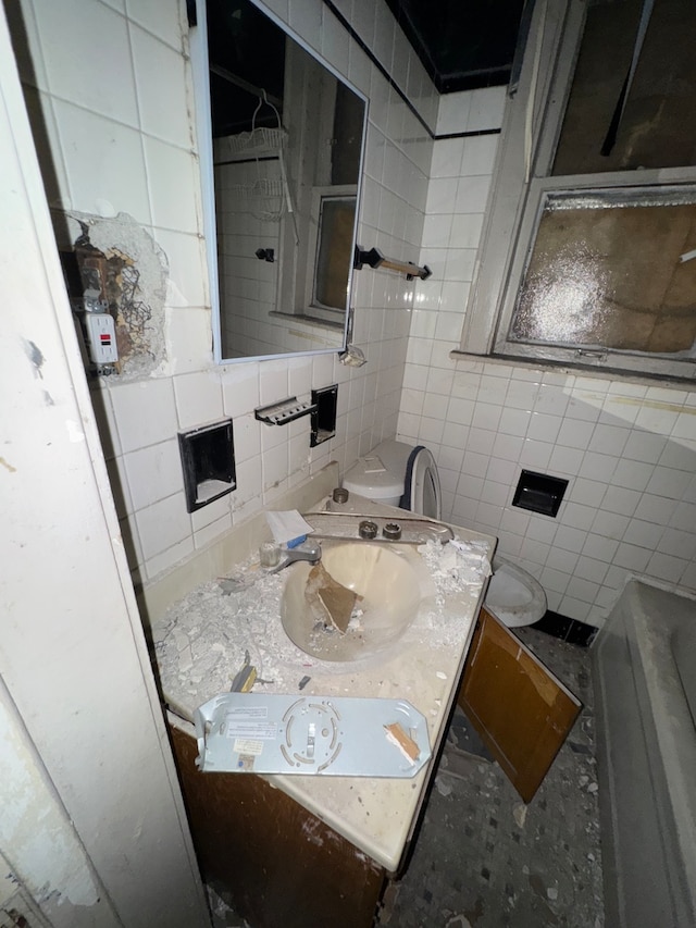 bathroom featuring vanity, toilet, and tile walls