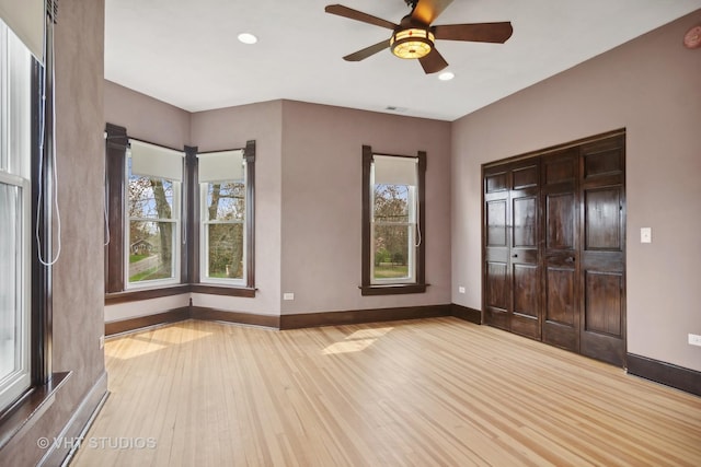 unfurnished bedroom with light wood-type flooring, a closet, and ceiling fan