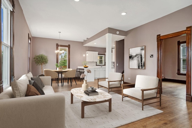 living room with a chandelier and light hardwood / wood-style flooring