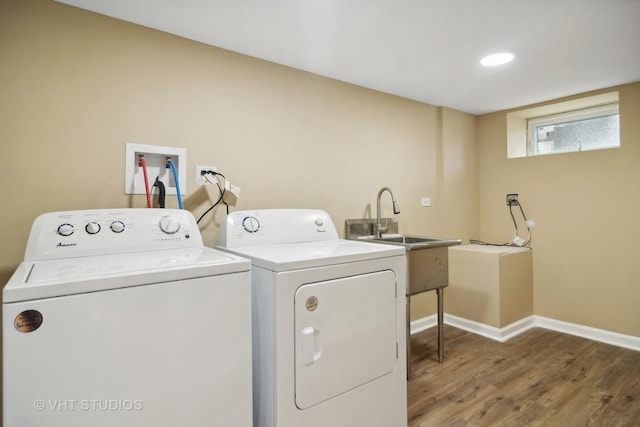 laundry room with wood-type flooring, sink, and washing machine and clothes dryer