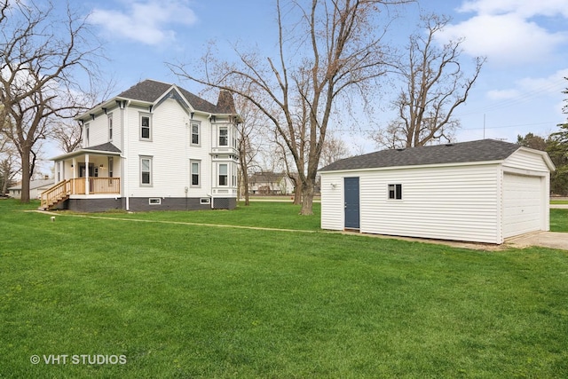 exterior space with a porch, a garage, an outdoor structure, and a yard