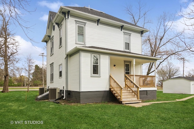 front of property with covered porch, central AC, and a front lawn