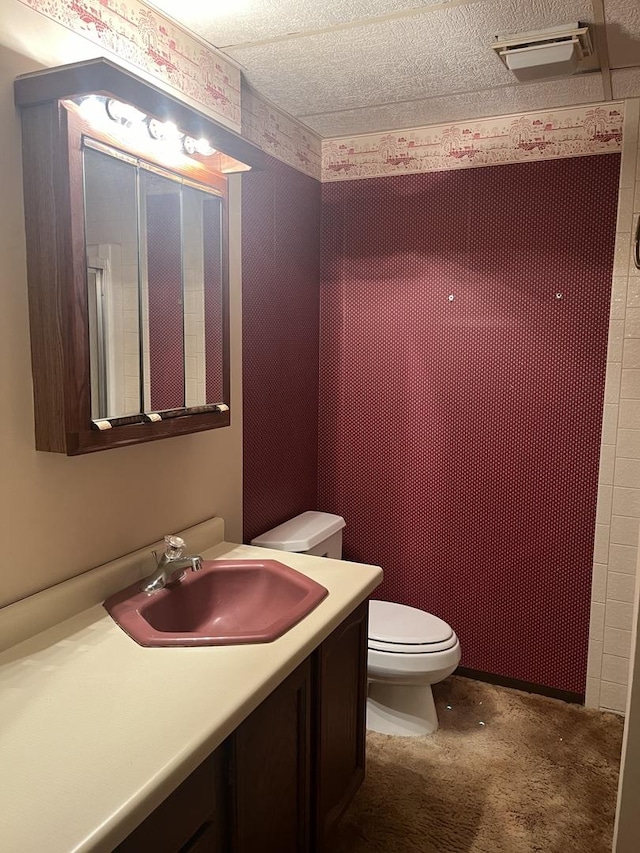 full bathroom with toilet, vanity, and a textured ceiling