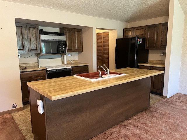 kitchen with black appliances, a sink, dark brown cabinets, a textured ceiling, and a kitchen island with sink