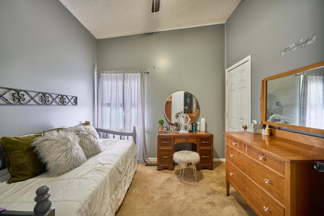 carpeted bedroom featuring ceiling fan, high vaulted ceiling, and a textured ceiling