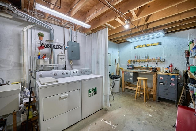 clothes washing area featuring sink, electric panel, washing machine and dryer, and a workshop area