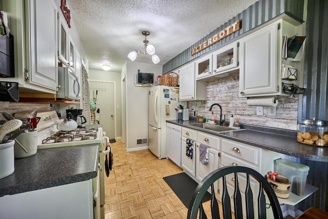 kitchen with decorative backsplash, white cabinetry, sink, and white appliances