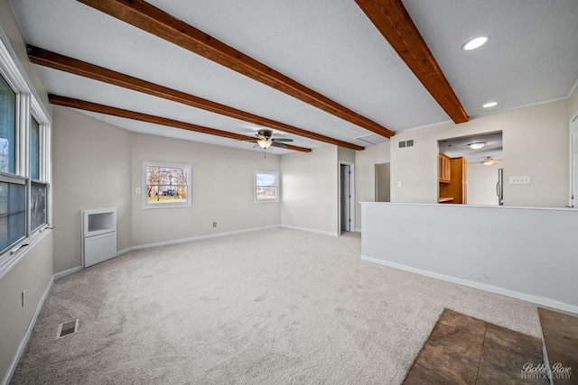 unfurnished living room with ceiling fan, beam ceiling, and light carpet