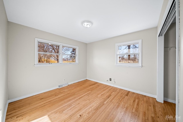 unfurnished bedroom featuring a closet and light hardwood / wood-style floors