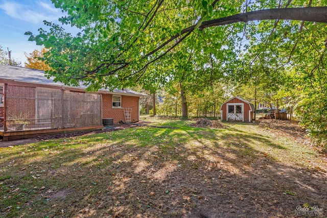 view of yard with central AC and a shed